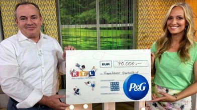 Charity-Gesamtleiter Wolfram Kons freut sich, einen Spendenscheck von Procter & Gamble entgegennehmen zu dürfen